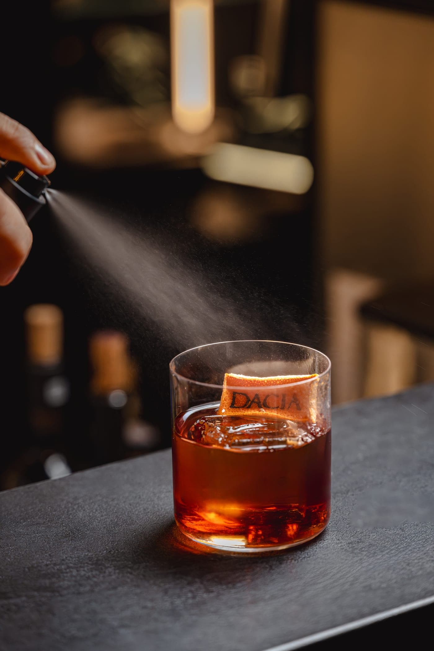 Negroni semnătura Dacia — cub de gheață gravat cu sigiliul casei și pulverizare de coajă de portocală